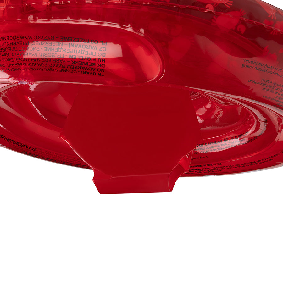 Close-up of the bottom of a transparant red baby float with the warning on it on a white background