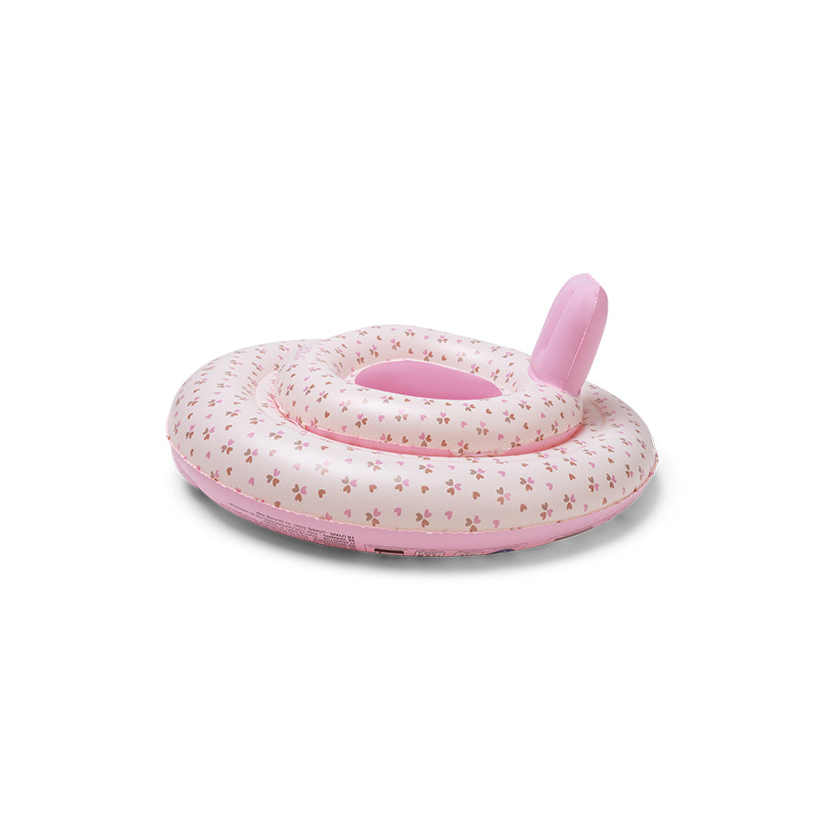 The side of the pink and beige baby float with hearts pattern on it with a small swim essentials logo on it on a white background.