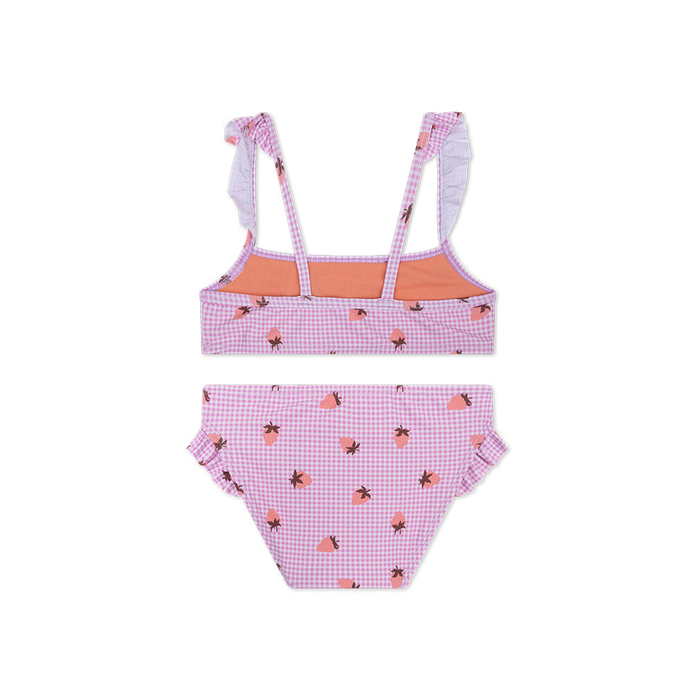 The back of a pink checkerd bikini with a strawberry print on a white background