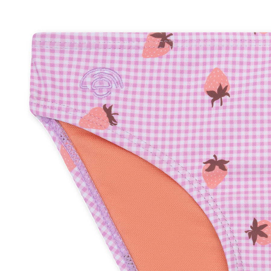 Close-up of a pink checkerd bikini with a strawberry print on a white background