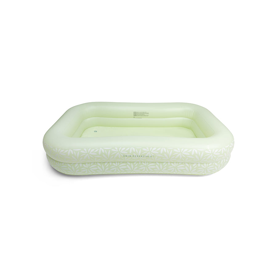 Green inflatable pool with flowers on it on a white background.