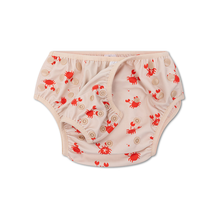 Beige swim diaper with a pattern of red crabs. Here you can see the snaps on the inside against a white background.