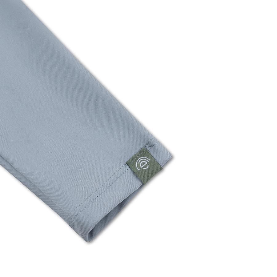 Green long-sleeve swim shirt with a green tag with a white 'Swim Essentials' logo on a white background.