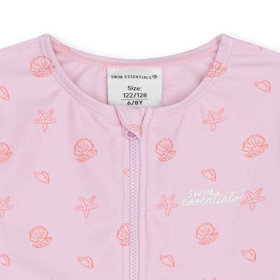 Close-up of the Pink Shell Tastic swimsuit with seashell print, including the Swim Essentials logo and size label.