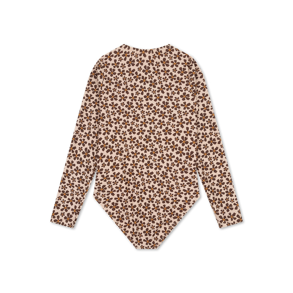 The back of a girls swimsuit with long sleeves with a wild flower pattern with orange in the middle on a white background.