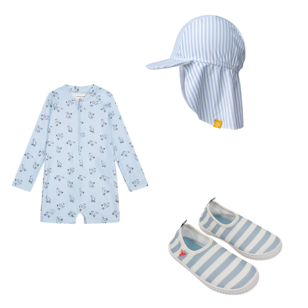 A set comprising a sun hat, a swimsuit and water shoes. The hat is white with blue stripes and has a neck flap that offers protection from the sun. The swimsuit is light blue and features a seagull print. It has long sleeves and short legs. The water shoes have white and blue stripes with a red lobster on the side of the heel, set against a white background.
