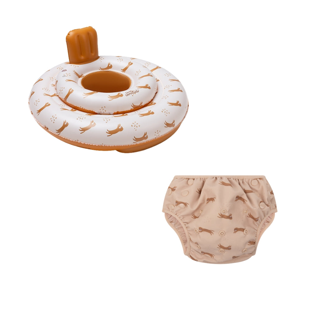 This is a set comprising a baby float and a diaper. The baby float features the ‘Roamer’ print. The top is beige with a tiger and paw print. The bottom and neck support of the baby float are brown. The diaper is beige with a tiger and paw print on a white background. 