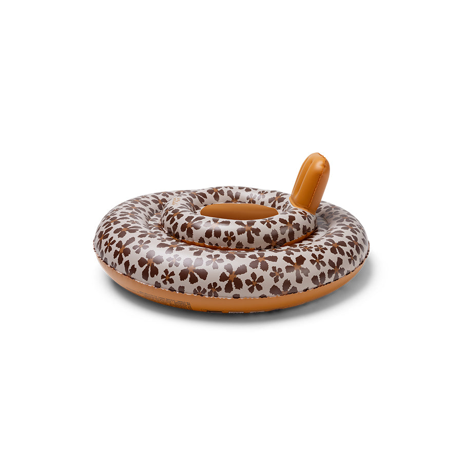 The side of a baby float with a floral pattern, a beige base and brown flowers. The bottom and neck support are finished in a brown color. The picture has a white background.