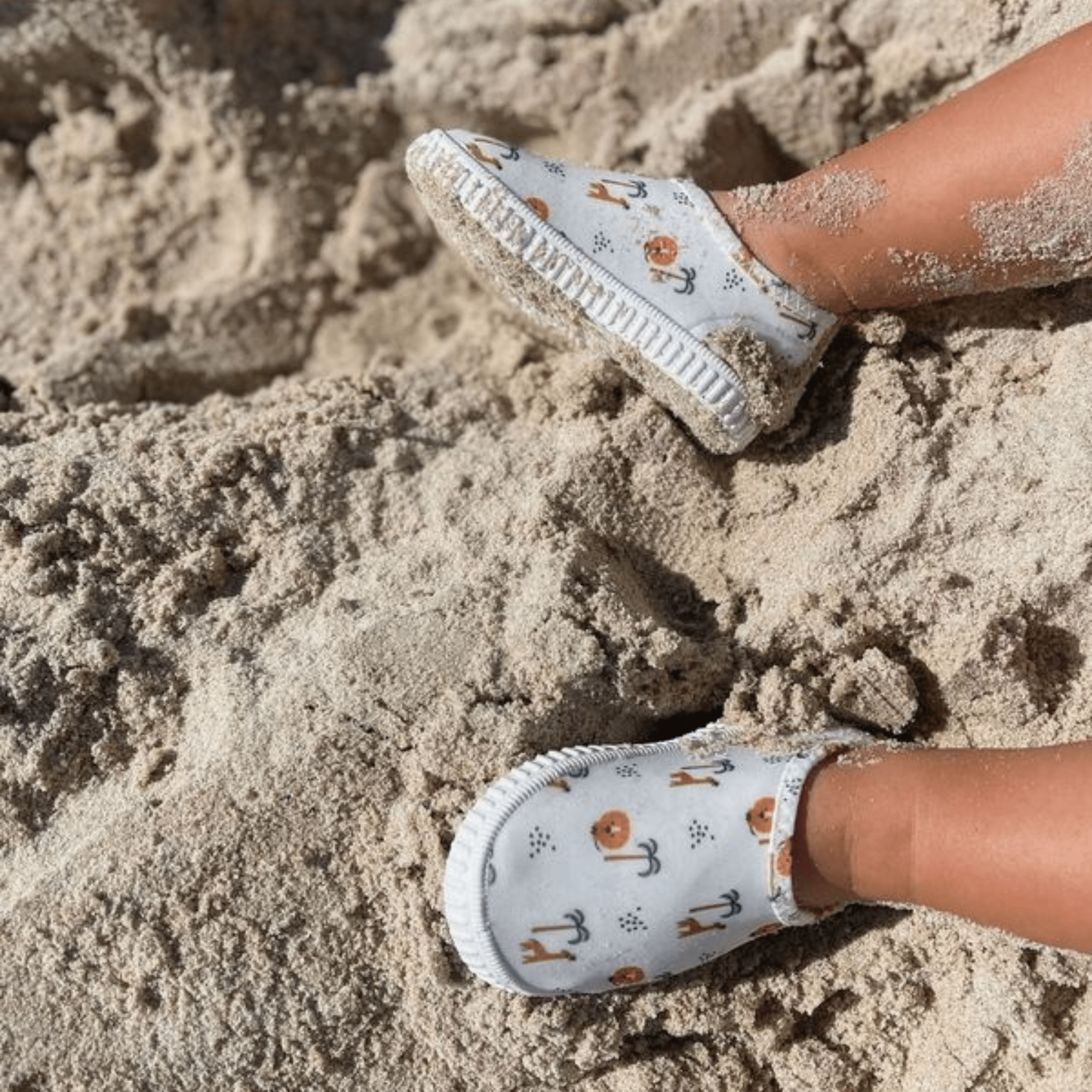 Children's water shoes with animal pattern on a sandy surface