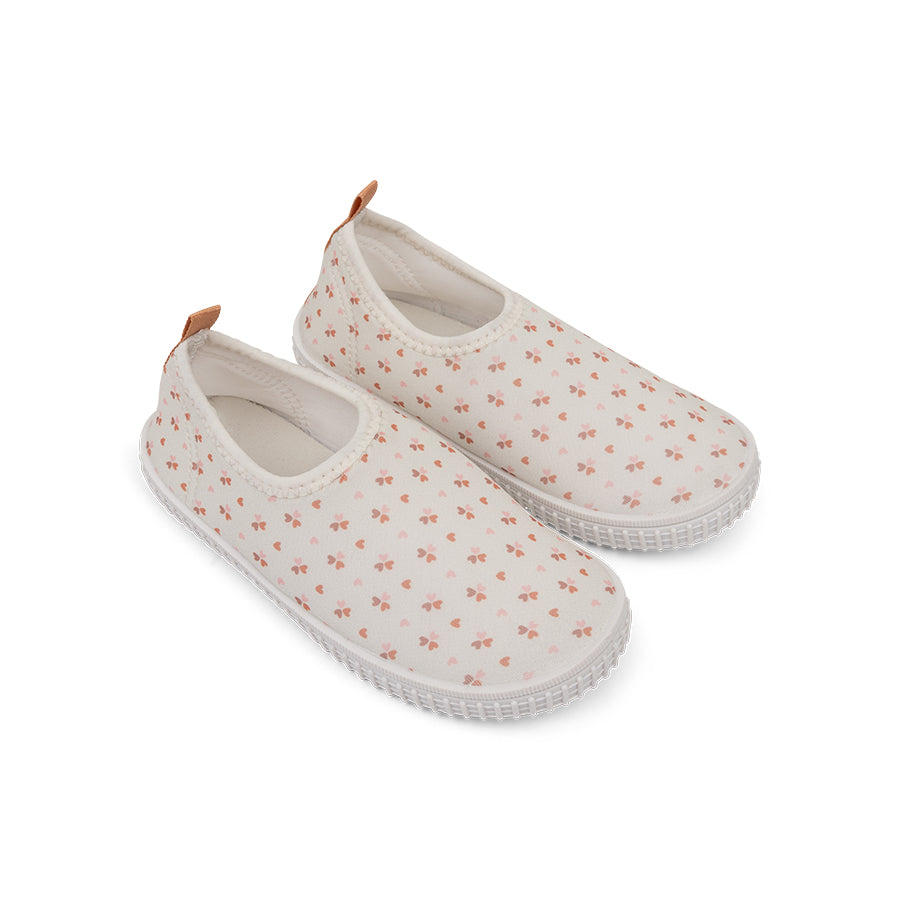 Pair of white slip-on water shoes with small floral pattern on a white background