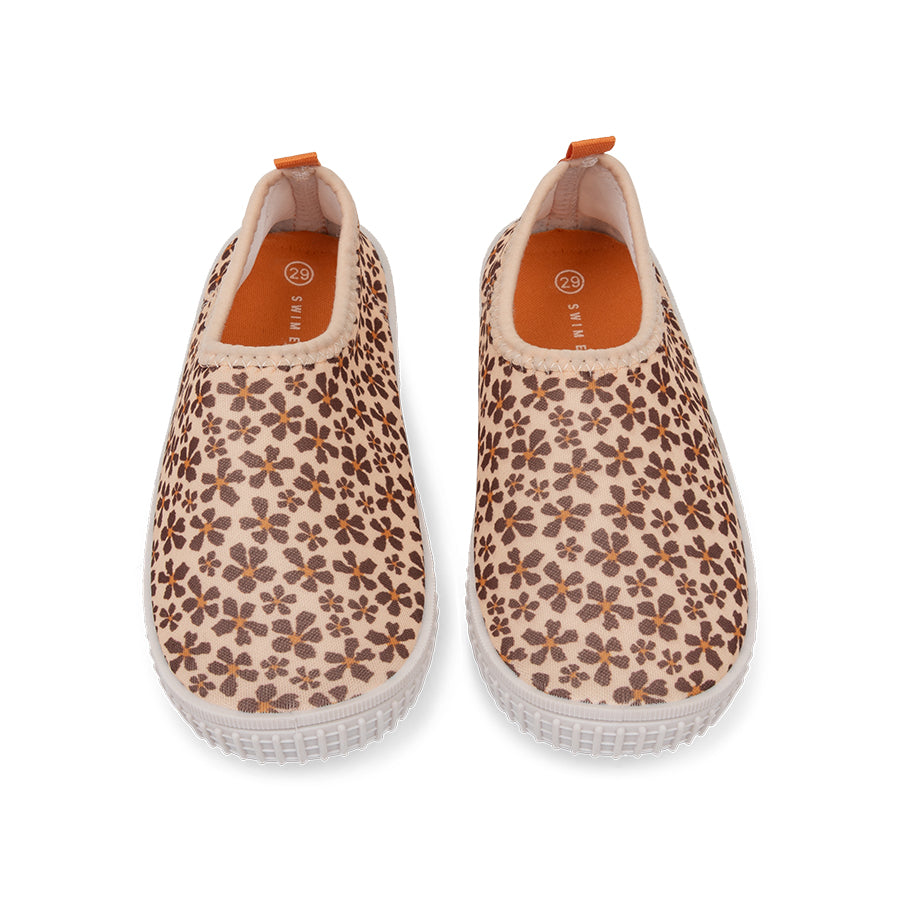 Pair of floral-patterned water shoes with white  soles on a white background