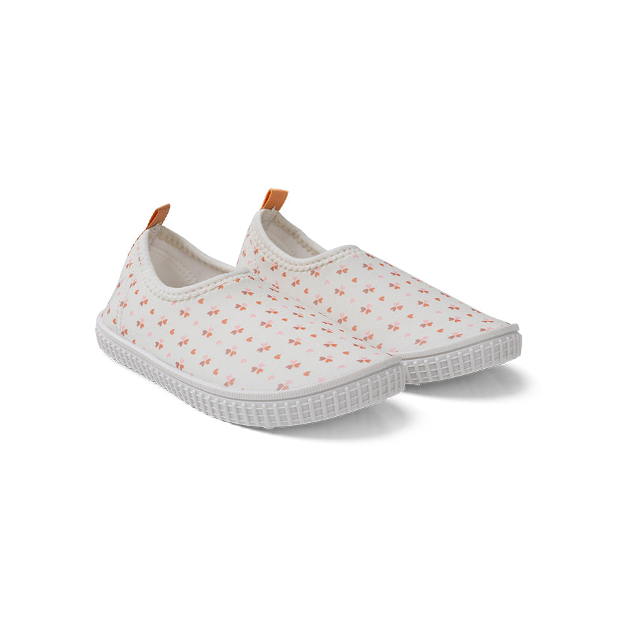 Pair of white slip-on water shoes with small floral pattern on a white background