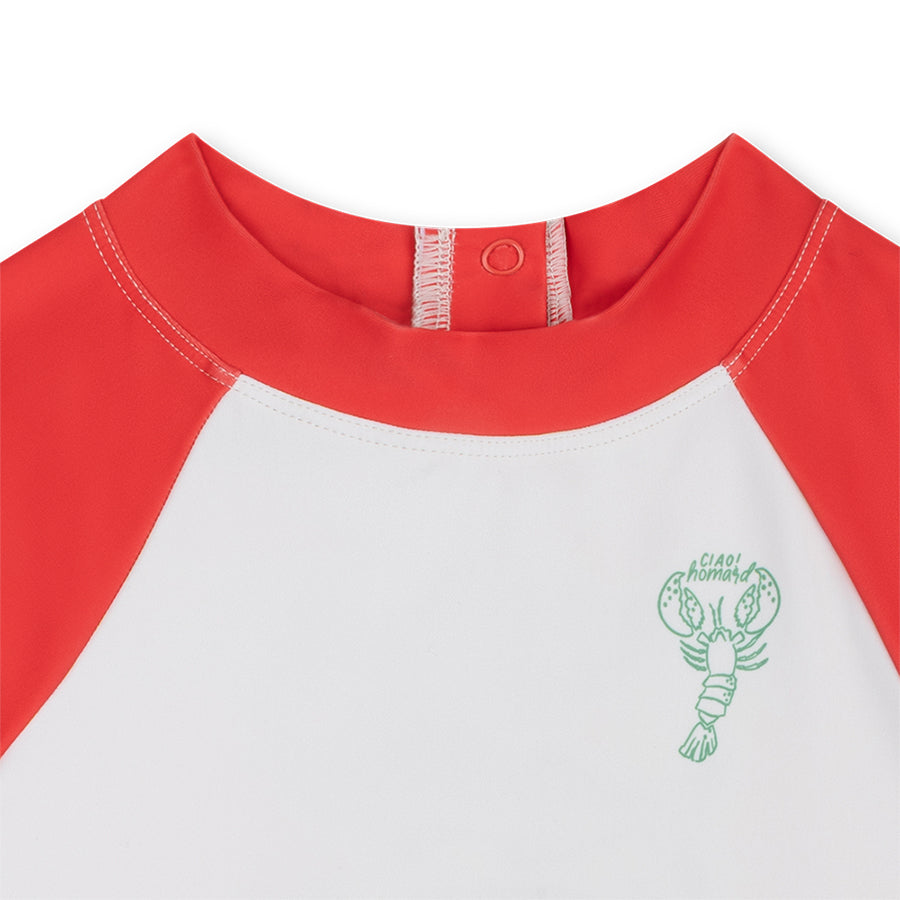 Close-up of a red and white shirt with a green lobster logo on a white background