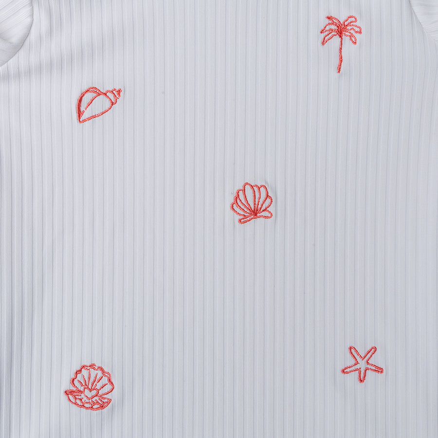 White short-sleeve shirt with red embroidered patterns of a palm tree, shell, and leaf on a textured background.