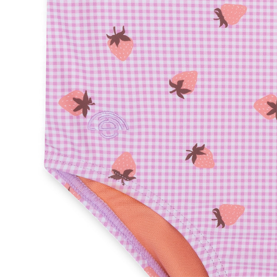 Pink swimsuit with strawberry pattern and visible brand logo.