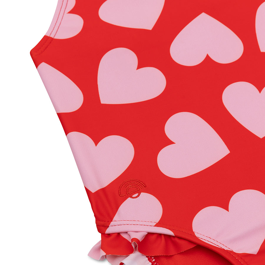 Red swimsuit detail picture with pink heart patterns on a white background